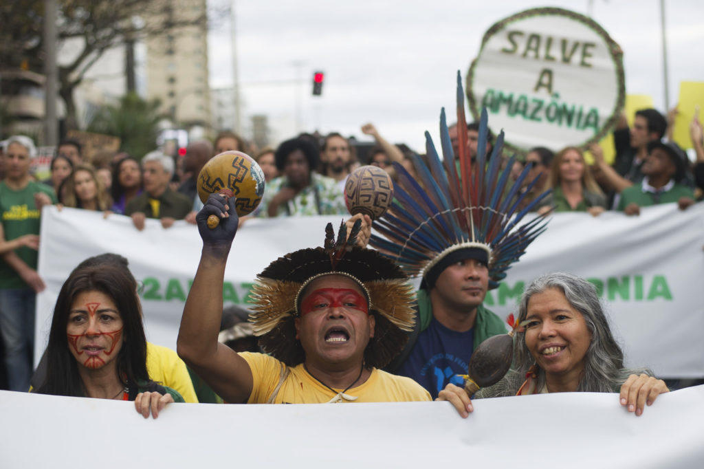 Indigenous people protest in defense of the Amazon in Rio de Janeiro on Sunday. Experts from the country's satellite monitoring agency say most of the fires are set by farmers or ranchers clearing existing farmland, but the same monitoring agency has reported a sharp increase in deforestation this year as well.