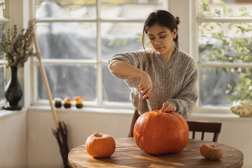Woman carving pumpkin CREDIT Unsplash