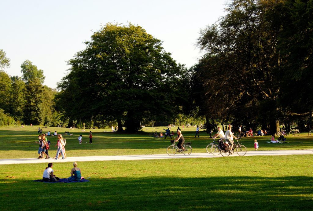 People and trees in a park located within an urban city area